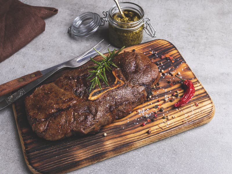 Grilled Beef Steak with Bone on a Cutting Board, Spices Stock Image