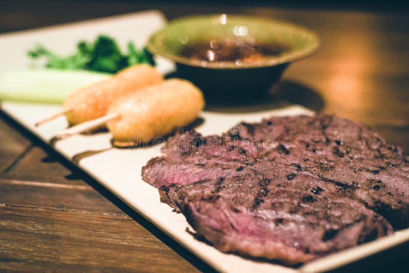 Grilled Beef Steak with Grilled Rice Cake on a Stick Stock Image