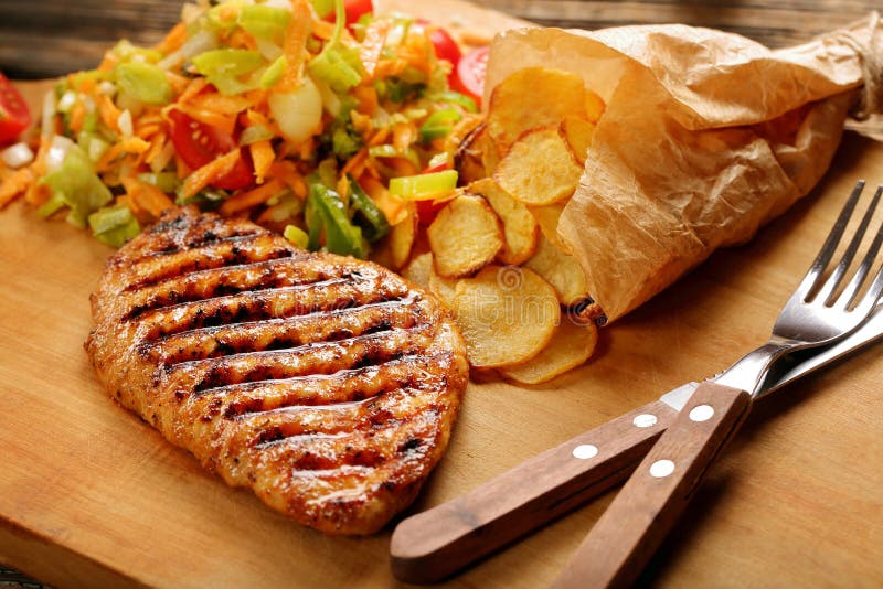 Grilled Chicken Breast Fillet with Potato Chips and Salad Stock Image