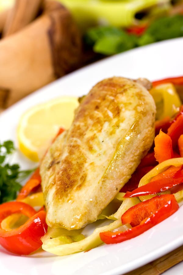 Grilled chicken breasts on a plate with fresh vege