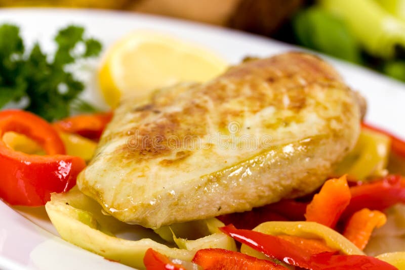 Grilled chicken breasts on a plate with fresh vege