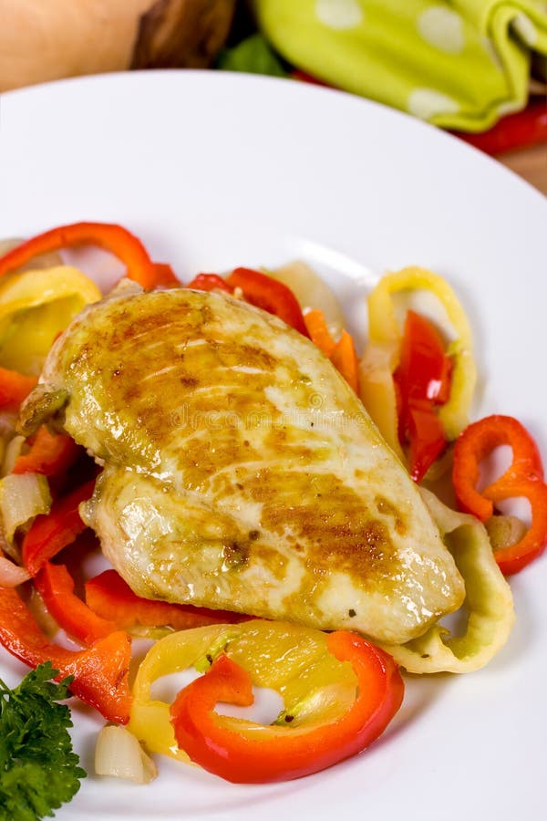 Grilled chicken breasts on a plate with fresh vege