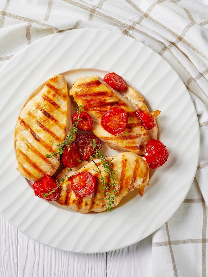 Grilled chicken breasts with tomatoes on a plate