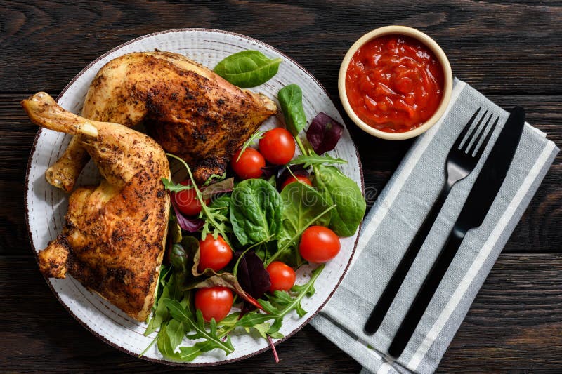 Grilled chicken leg quorters with salad mix and tomatoes.