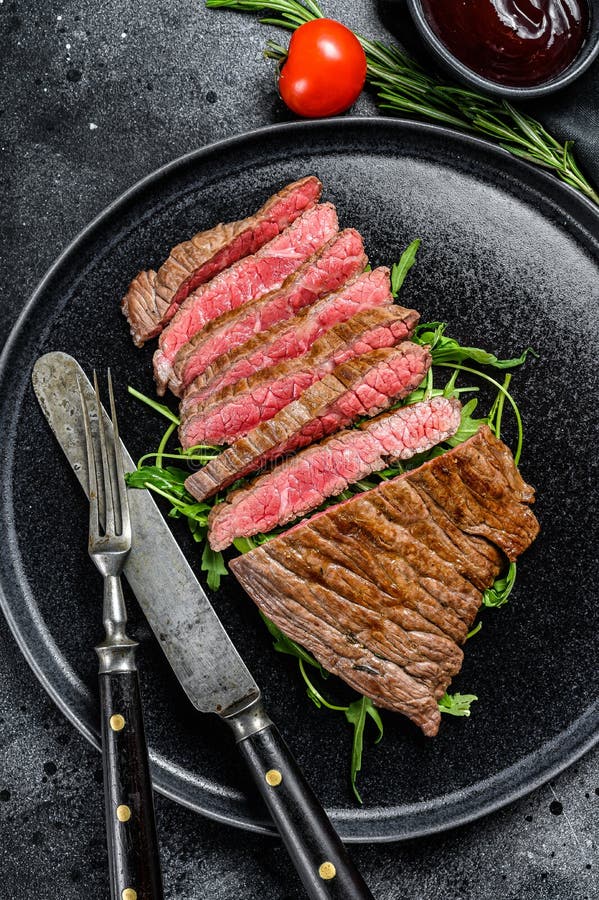 Grilled and Cut Flank Steak. Marble Beef Meat. Black Background Stock