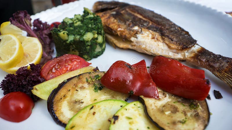 Grilled fish with various vegetables stock image
