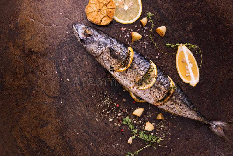 Grilled fish and various vegetables in iron plate stock images