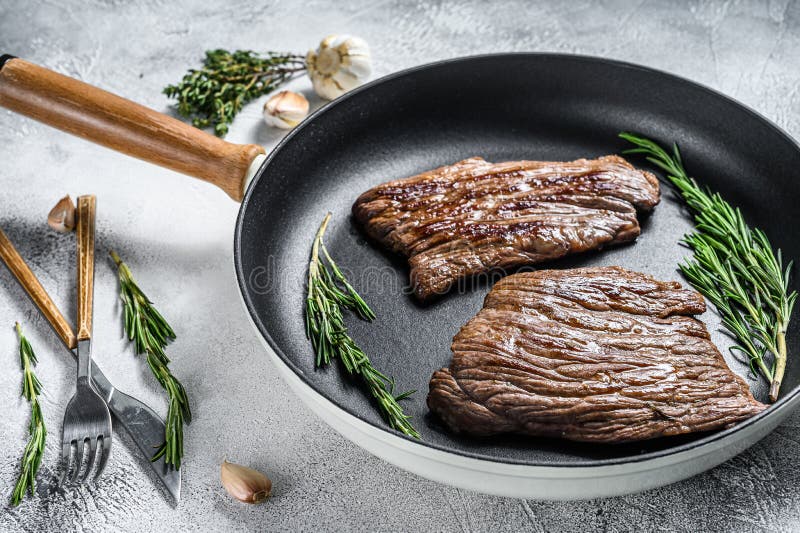 Grilled Flat Iron and Flank Steaks in a Pan. Marble Beef Meat. Gray
