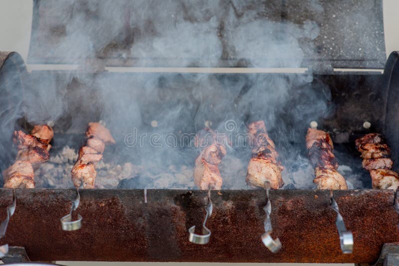 Grilled kebab cooking on metal skewer closeup. Roasted meat cooked at barbecue. BBQ fresh beef meat chop slices