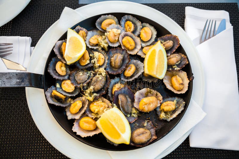 Grilled limpets served with lemon