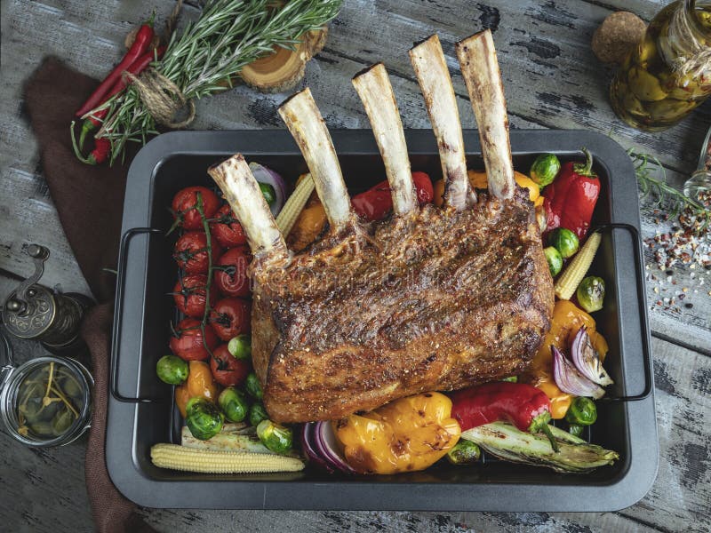 Grilled Roasted Rack of Lamb Chops with Vegetables, on a Wooden Surface