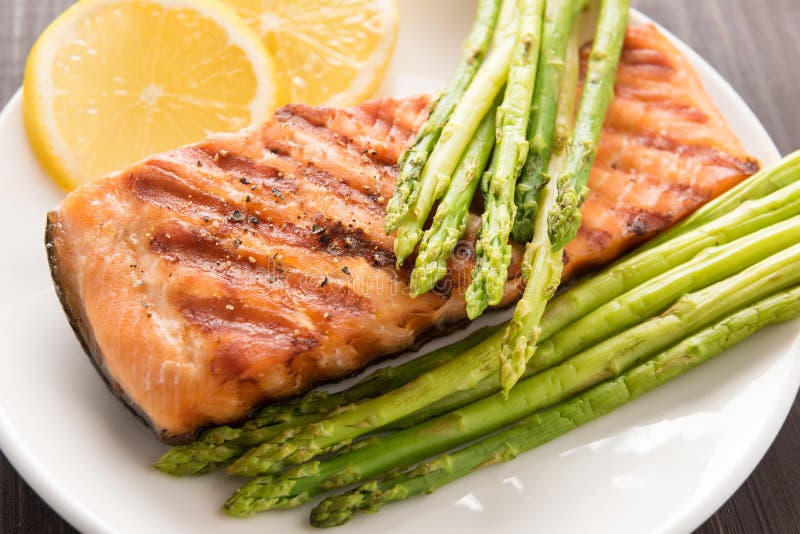 Grilled Salmon with Lemon, Asparagus on the Wooden Background Stock ...