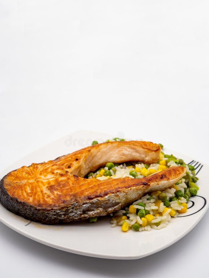 Grilled salmon steak with rice and vegetables. royalty free stock photo