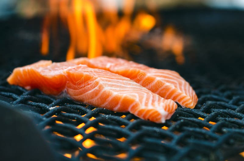 Grilled salmon steaks on a grill. Fire flame grill. Restaurant and garden kitchen. Garden party. Healthy dish.