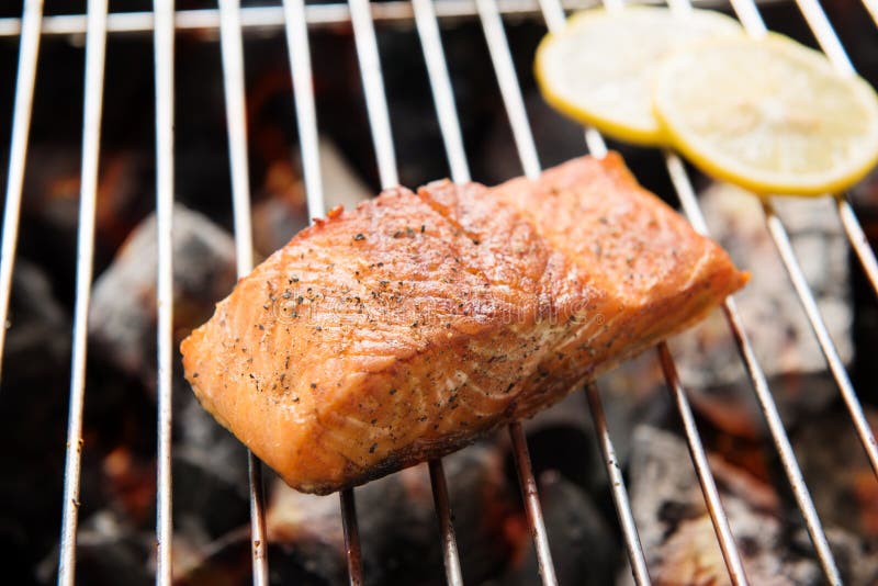 Grilled salmon steaks and lemon on the flaming