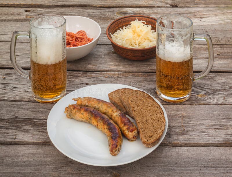 Grilled Sausage on a Plate and Glasses with a Light Beer Stock Image ...