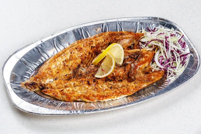 Grilled Sea Bream Fish on Foil Plate Served with Lemon and Cauliflower