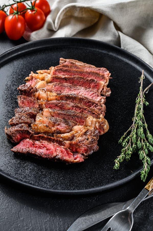 Grilled Sliced Steak Rib Eye with Pepper. Black Background Stock Image