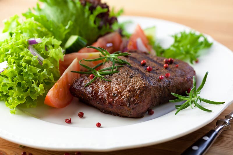 Grilled steak with fresh vegetables and herbs