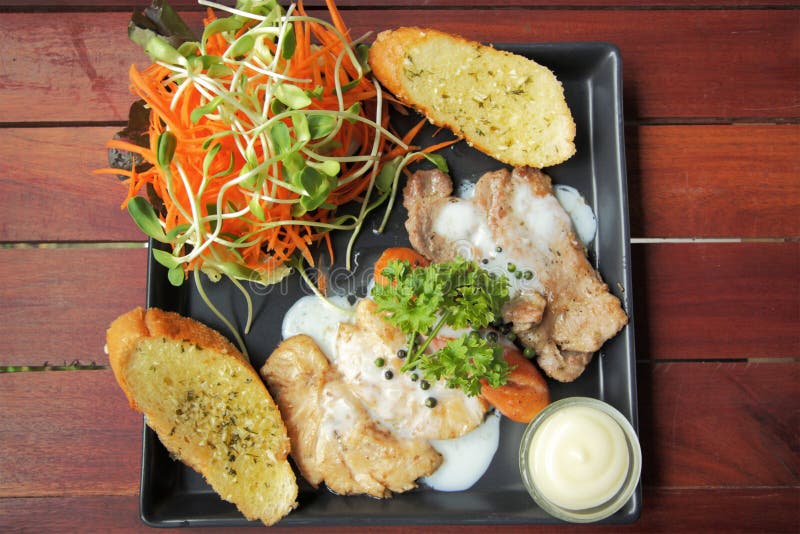 Grilled Steaks, Sausage, Garlic Bread and Salad Recipe Stock Photo