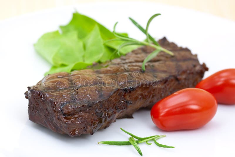 Grilled strip steak with tomato and salad