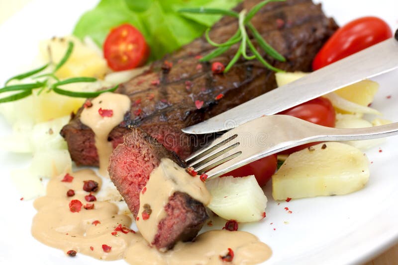 Grilled strip steak with tomato and salad