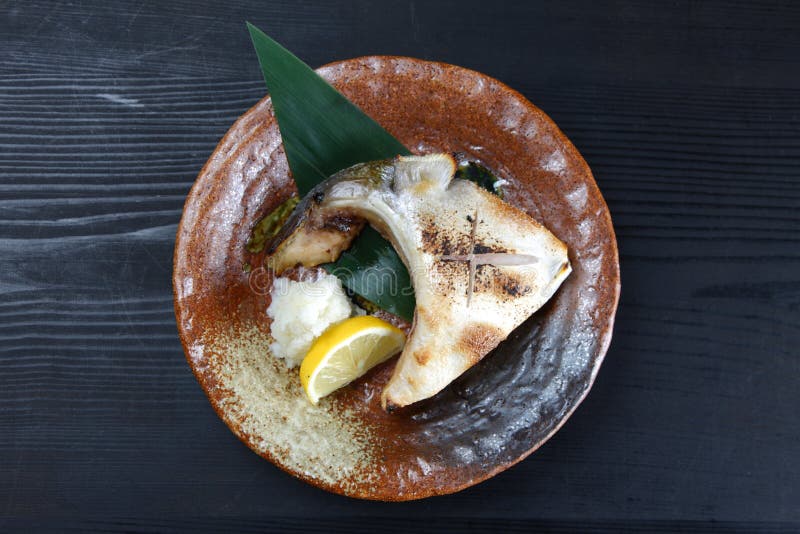 Grilled yellowtail collar on a dining table