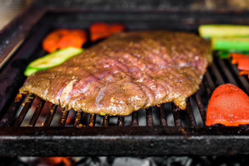 Grillen des marinierten Angus-Rindfleischbauchlappens auf heißem Kohlengrillgrill stockfotografie