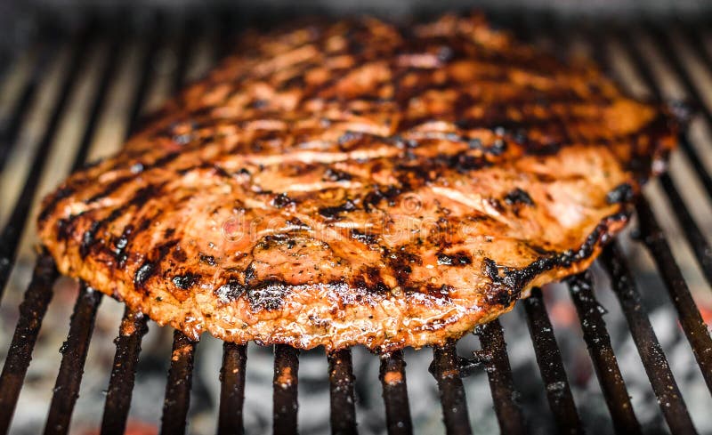 Grillen des marinierten Angus-Rindfleischbauchlappens auf heißem Kohlengrillgrill stockfotos