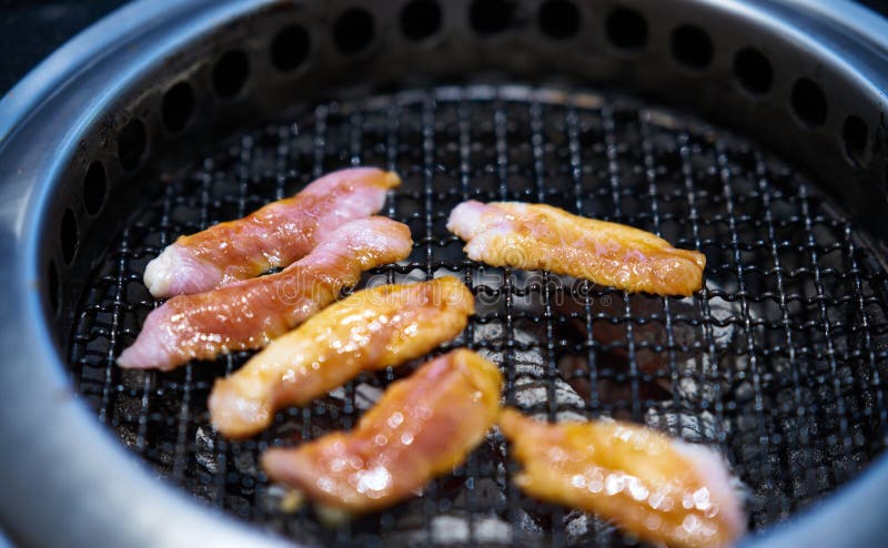 Grillen von rohem Fleisch im rohen Brennholz-Ofen im asiatischen Restaurant stockfotografie Grillen von rohem Fleisch im rohen Brennholz-Ofen im asiatischen Restaurant stockfotografie
