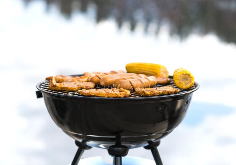 Grilling at the beach. Food cooking on a charcoal kettle grill stock photography Grilling at the beach. Food cooking on a charcoal kettle grill stock photography