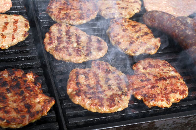 Grilling sausages, burgers, pork steak on barbecues gas grill for party. Hot dogs,sausages and hamburgers on a barbeque, bbq. Smok royalty free stock image Grilling sausages, burgers, pork steak on barbecues gas grill for party. Hot dogs,sausages and hamburgers on a barbeque, bbq. Smok royalty free stock image