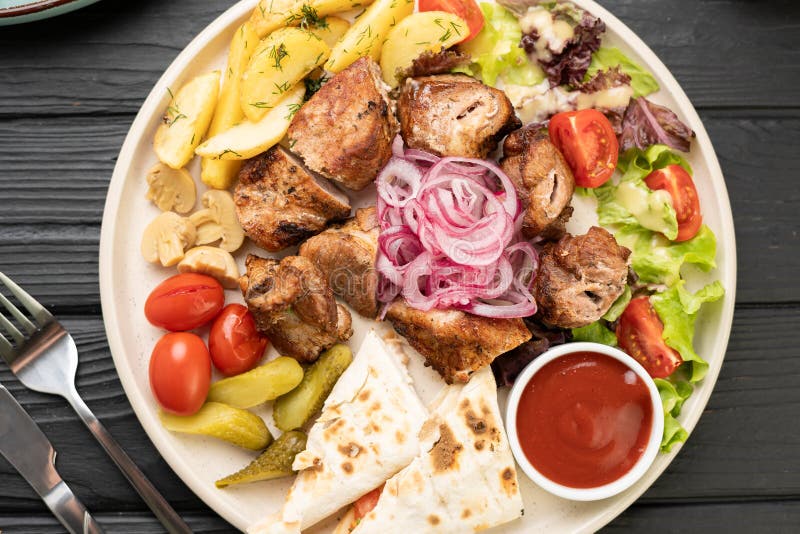 Grillowany kebab wieprzowy serwowany z talerzem warzywnym obrazy royalty free
