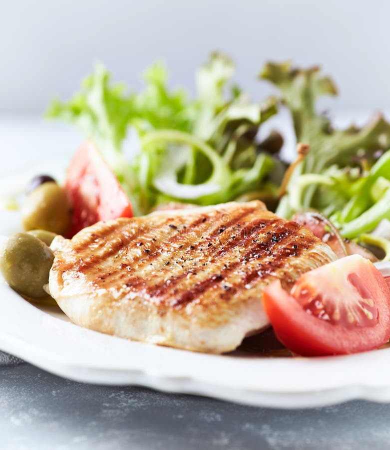 Grilltes türkisches Brust mit frischem Salat. Heller Hintergrund. Schließen.