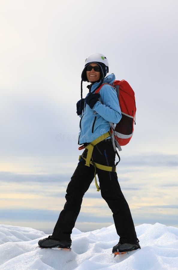Grimpeur de femme se tenant sur le dessus glacial du glacier photographie stock libre de droits Grimpeur de femme se tenant sur le dessus glacial du glacier photographie stock libre de droits
