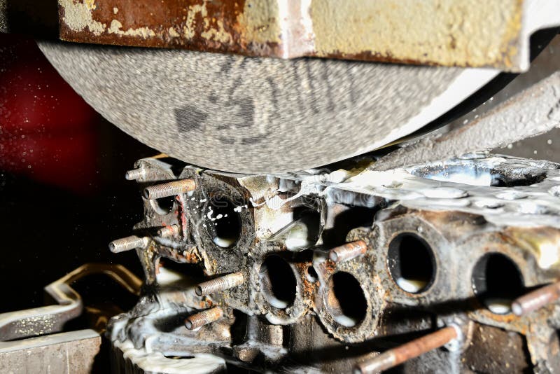 Grinding the cylinder head of a car engine on a water-cooled surface grinder royalty free stock photos
