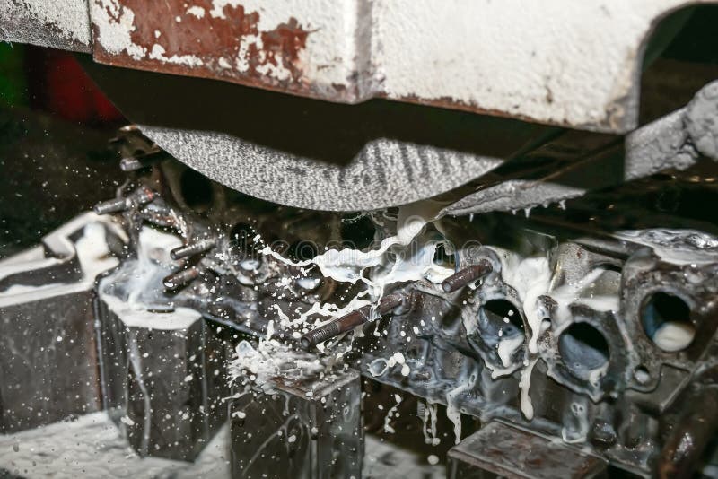 Grinding the cylinder head of a car engine on a water-cooled surface grinder stock photos