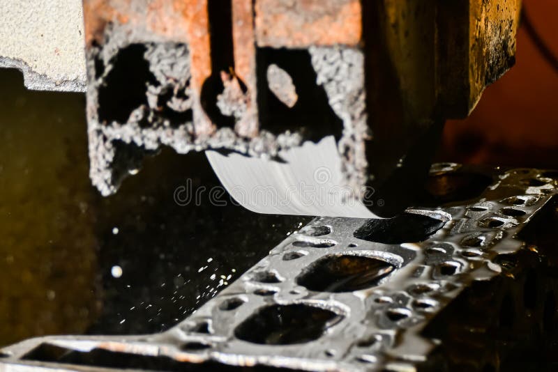 Grinding the cylinder head of a car engine on a water-cooled surface grinder royalty free stock image