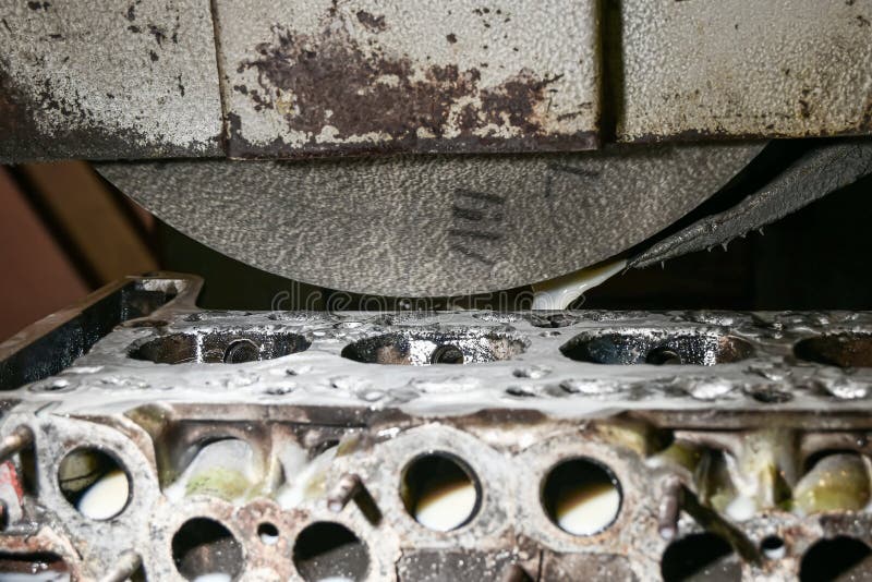 Grinding and finishing of the cylinder head of a car engine on a surface grinder stock photos