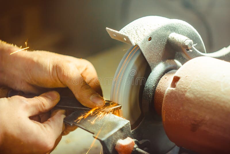 Knife sharpener and hand with blade on wooden table, closeup. Closeup machine tool stock images, royalty-free photos and pictures