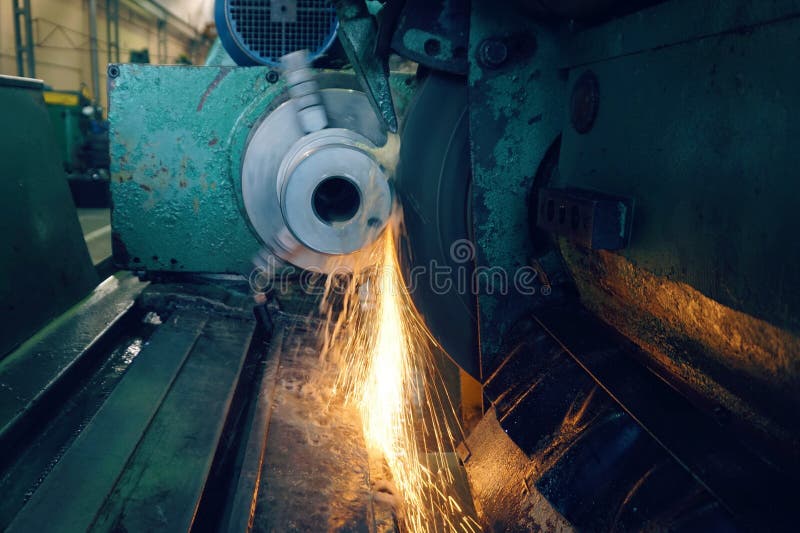 Grinding of metal, final processing of a part on a precision grinding machine with sparks and cooling. stock image