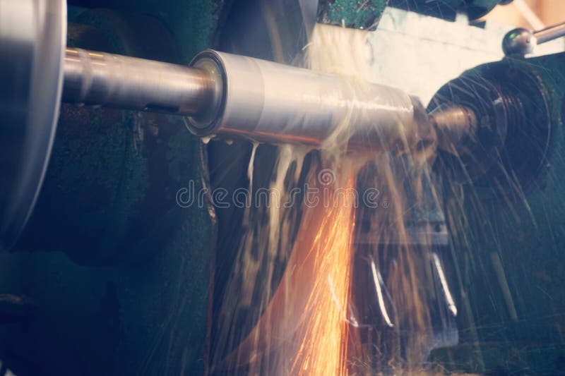 Grinding the shaft on the machine with sparks and cooling, at different angles. stock photos