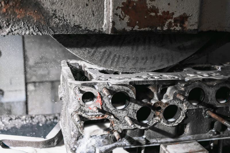 Grinding the surface of the cylinder head on a surface grinder stock images