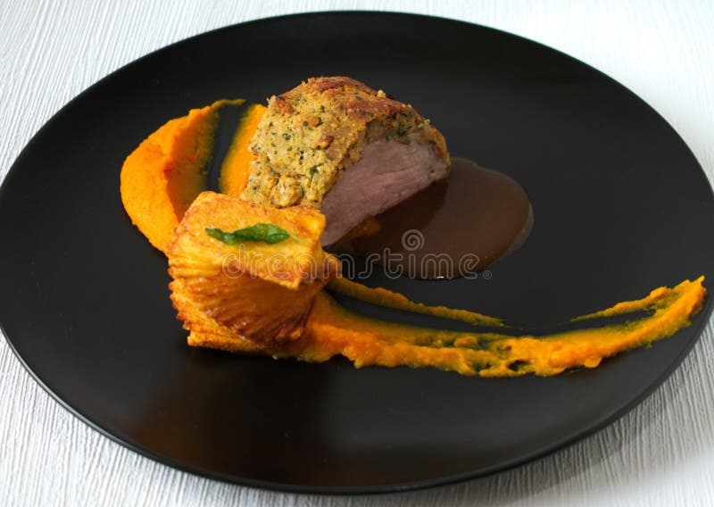 Grisköttfilet med pumpakräm och buntpotatisen royaltyfria bilder