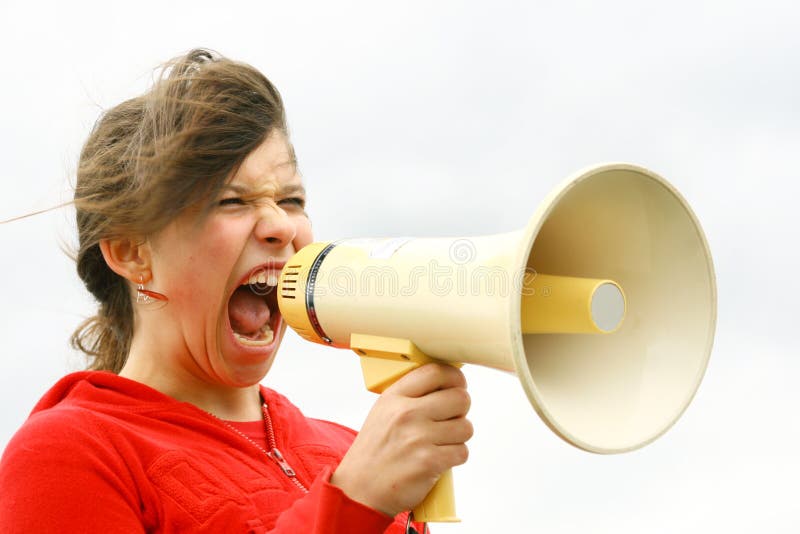 Young teen yelling through a speakerphone. Young teen yelling through a speakerphone