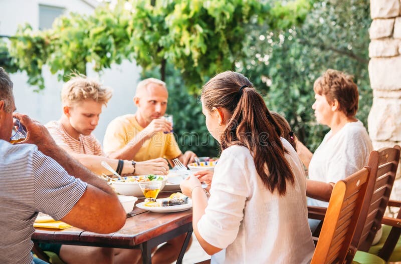 Gro?e Familie essen auf offener Gartenterrasse zu Abend lizenzfreies stockfoto Gro?e Familie essen auf offener Gartenterrasse zu Abend lizenzfreies stockfoto