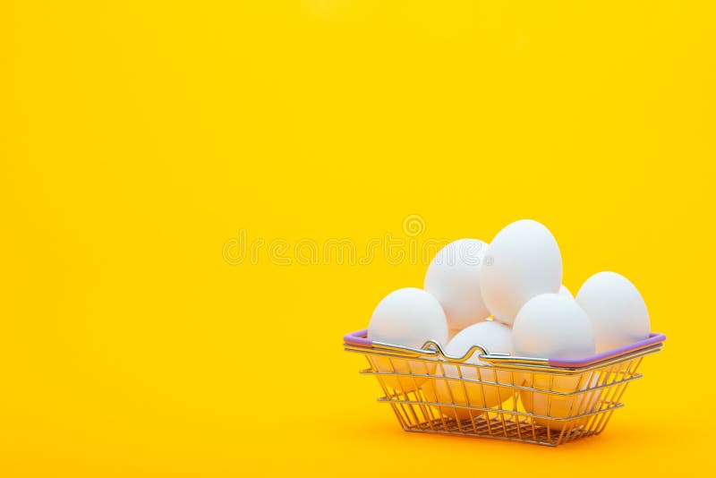 Grocery basket with chicken eggs on an orange background