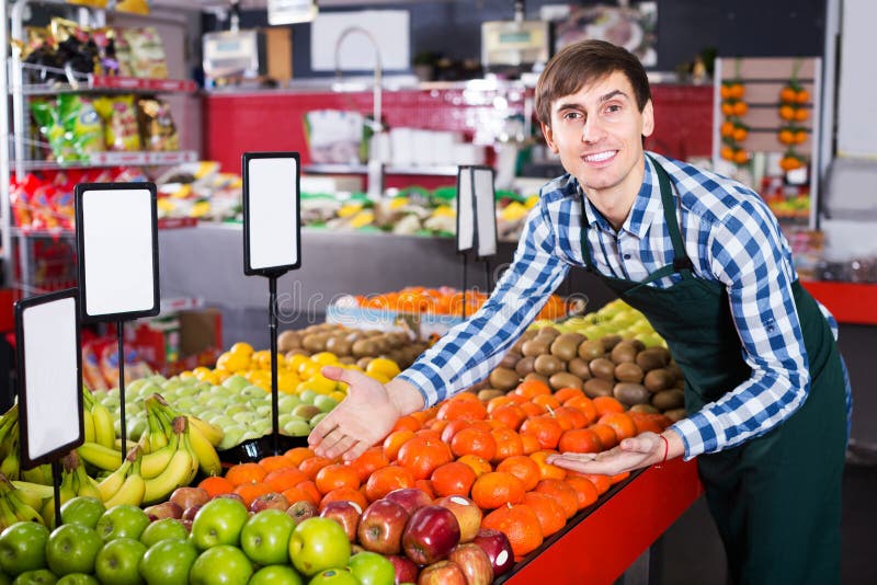 Grocery worker selling seasonal fruits