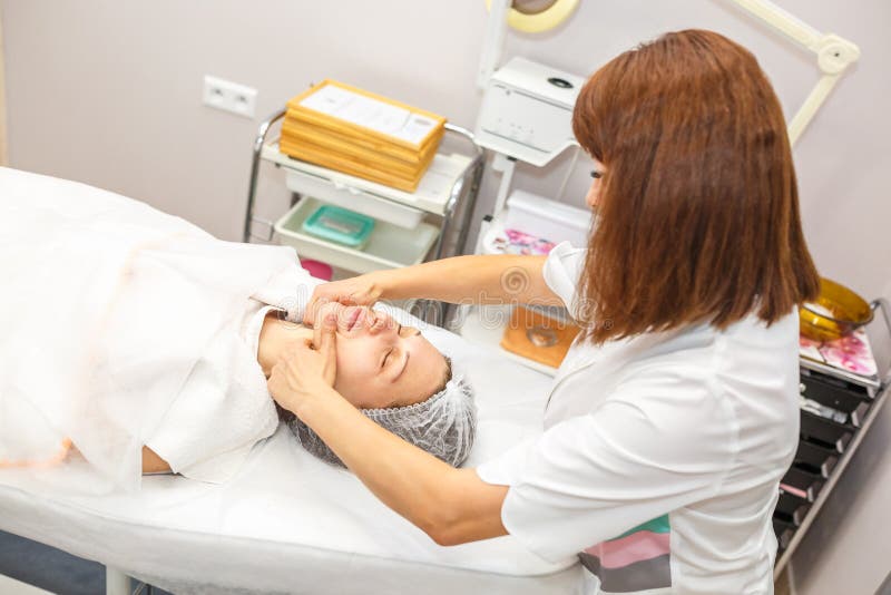GRODNO, BELARUS - MAI 2018 : femme faisant le massage facial au salon de beauté image stock GRODNO, BELARUS - MAI 2018 : femme faisant le massage facial au salon de beauté image stock
