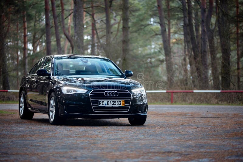 GRODNO, BELARUS - DECEMBER 2019: Audi A6 4G, C7 2.0 TDI 190 Hp 2016 facelift three fourth view outdoors on winter road during testdrive with forest on background. GRODNO, BELARUS - DECEMBER 2019: Audi A6 4G, C7 2.0 TDI 190 Hp 2016 facelift three fourth view outdoors on winter road during testdrive with forest on background